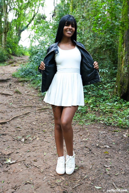 Brunette beauty relaxes in forest clearing