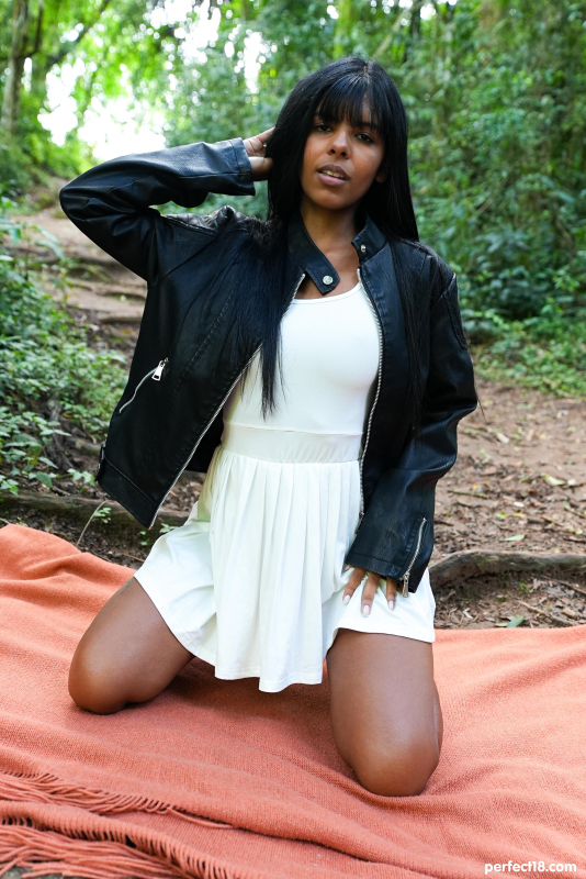 Brunette beauty relaxes in forest clearing
